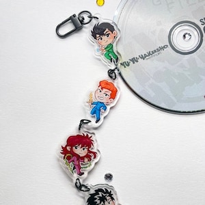 以下が含まれることがあります： 幽☆遊☆白書 のアニメキャラクター4体が付いたキーホルダー。キャラクターは幽助、蔵馬、飛影、桑原。キーホルダーは透明アクリル製で、黒い金属製の留め具が付いています。