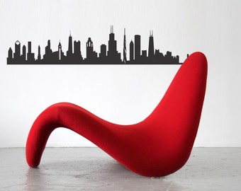 Könnte beinhalten: Ein roter, modern gestalteter Loungesessel mit geschwungenem Design. Oberhalb des Stuhls befindet sich eine schwarze Silhouette der Skyline von Chicago an einer weißen Wand. Die leuchtende Farbe des Stuhls kontrastiert mit dem neutralen Hintergrund.