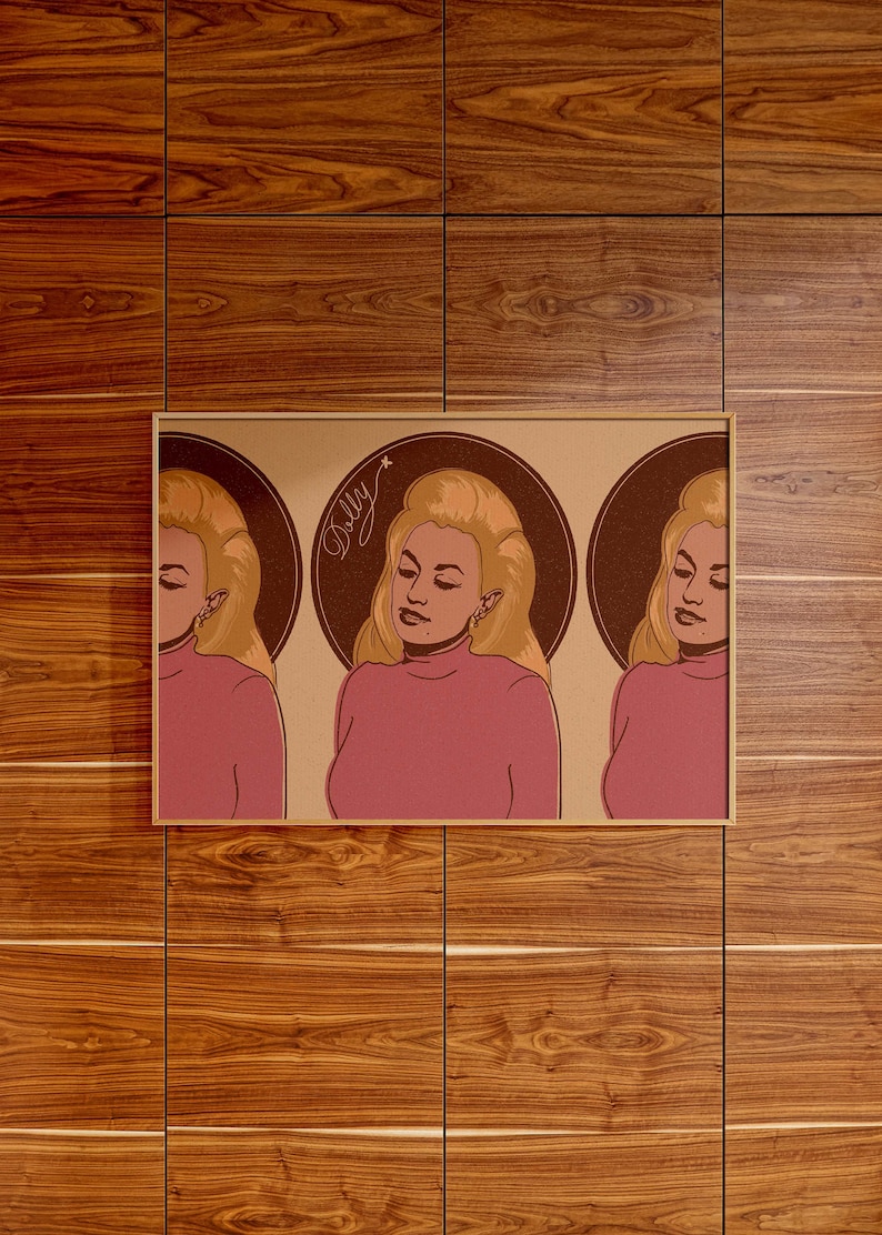 May include: A framed print featuring a pop art style illustration of a woman with blonde hair and a pink turtleneck. The image is repeated three times, each within a brown circular background. The word "Dolly" is written in cursive.