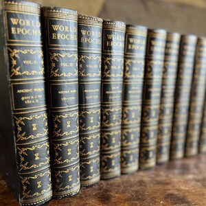 May include: A collection of antique books titled "World Epochs" with black covers and gold lettering. The spines display volume numbers and historical periods like "Ancient World" and "Middle Ages." The books are arranged in a row, suggesting a historical or literary theme.