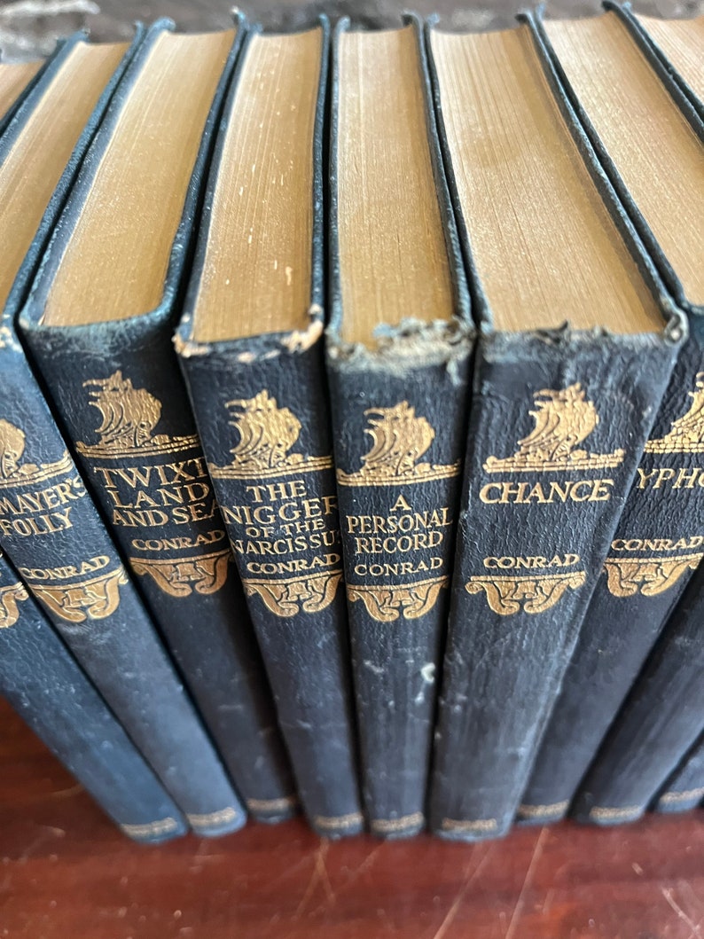 May include: A set of ten vintage hardcover books with gold lettering on black spines. The titles include "Mayer's Folly", "Twix Land and Sea", "The Nigger of the Narcissus", "A Personal Record", "Chance", and "Typhoon".