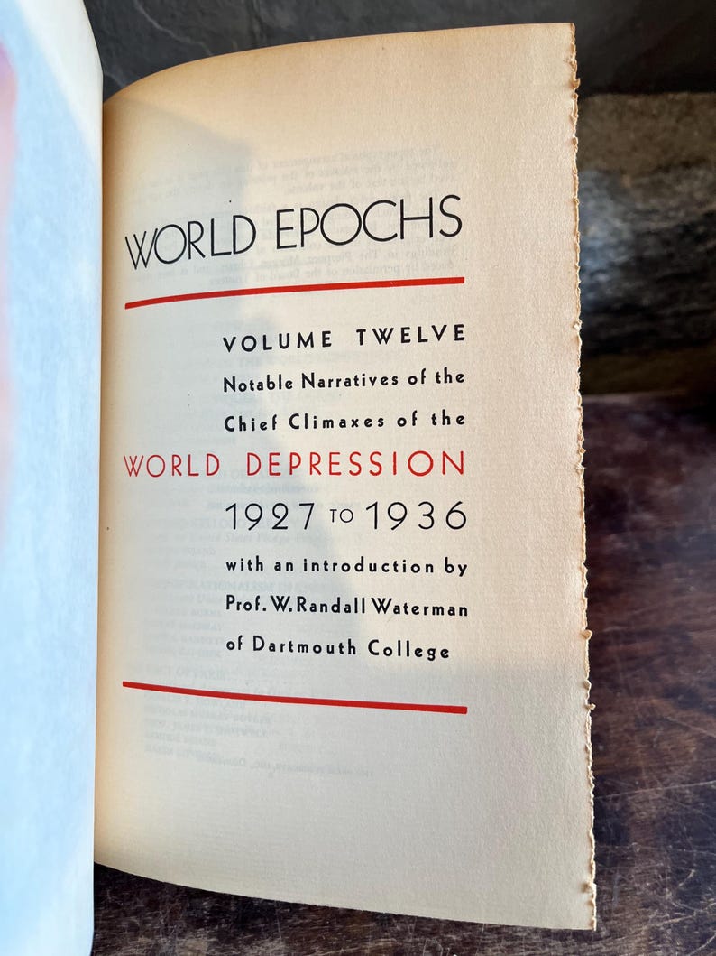 May include: Open book with the title "WORLD EPOCHS" in black font. The text "VOLUME TWELVE" and "WORLD DEPRESSION 1927 TO 1936" are also visible. The book's pages are aged with a slightly yellowed tone.