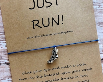 May include: A blue string bracelet with a silver running shoe charm. The card attached to the bracelet reads "JUST RUN!" and "Close your eyes and make a wish, then tie this bracelet upon your wrist. When the bracelet breaks in two, the wish you made may just come true!"