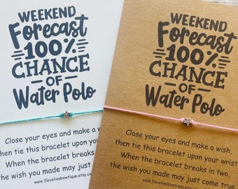Peut inclure: Deux cartes avec le texte "Weekend Forecast 100% Chance of Water Polo" et un bracelet à vœux. Une carte est blanche, l'autre est marron. Les bracelets sont turquoise et rose, chacun avec un charme en forme d'étoile.