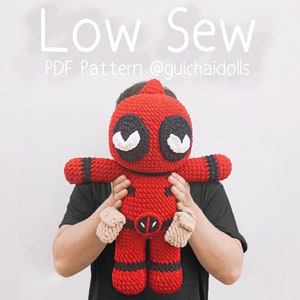 May include: A person holding a red and black crocheted Deadpool character. The character has a black mask with white eyes and a red suit with a black belt. The text "Low Sew PDF Pattern @guichaidolls" is above the character.