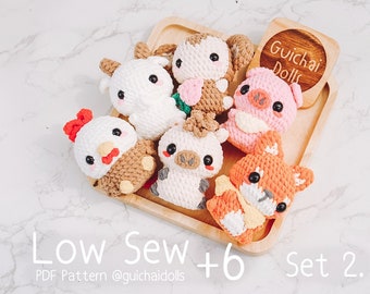 May include: A set of six crocheted animal plushies, including a pig, a goat, a chicken, a fox, a horse, and a cow. The plushies are all in different colors and have cute faces. The plushies are arranged on a wooden tray with the text "Guichai Dolls" on a wooden tag. The text "Low Sew +6 Set 2. PDF Pattern @guichaidolls" is at the bottom of the image.