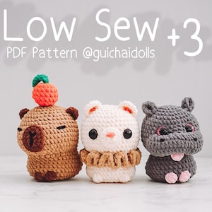 May include: Three crocheted stuffed animals: a brown capybara with an orange fruit on its head, a white bear with a brown collar, and a gray hippopotamus. The text "Low Sew +3 PDF Pattern @guichaidolls" is above the animals.