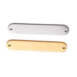 May include: Two rectangular metal name tags, one silver and one gold, with rounded edges and two holes for attaching.