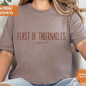 Może przedstawiać: Koszulka w kolorze pebble brown z napisem "FEAST OF TABERNACLES" w bordowym kolorze. Poniżej tekstu znajduje się "Leviticus 23". Koszulka marki Bella+Canvas.