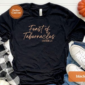 Może przedstawiać: Czarny T-shirt z napisem "Feast of Tabernacles" w kolorze miedzianym i napisem "Leviticus 23" mniejszą czcionką poniżej.
