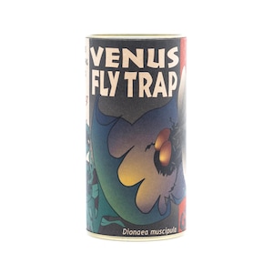May include: A cylindrical container with the words "VENUS FLY TRAP" in white block letters. The container features a colorful illustration of a Venus flytrap plant with a dark background and the scientific name "Dionaea muscipula".