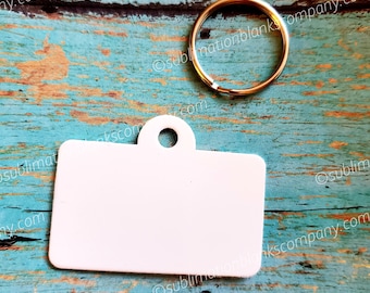May include: White blank rectangular keychain tag with a metal ring attached. The tag has a hole at the top for attaching to a keychain.