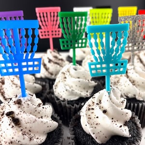 Miniature cupcakes with tiny acrylic disc golf baskets on top as decorations in a variety of different colors.