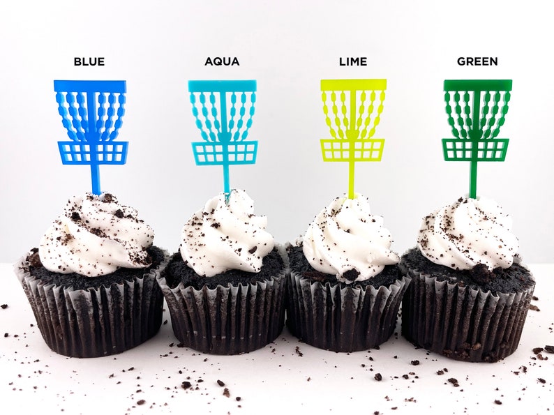 4 mini chocolate cupcakes with vanilla icing and cookie crumbles, decorated with tiny disc golf basket cupcake toppers in blue, aqua, lime, and green.