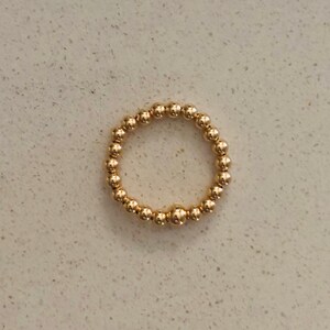 May include: A gold beaded ring with a simple design.