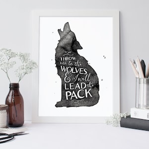 May include: Black and white watercolour print of a wolf howling with the text "Throw me to the wolves & I will lead the pack" in white lettering.