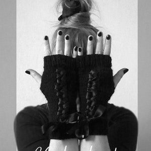 Puede incluir: Guantes sin dedos negros con dise&ntilde;o de cordones y lazos. Los guantes se muestran con el texto "Chakrakniits" en fuente cursiva. La imagen es en blanco y negro.