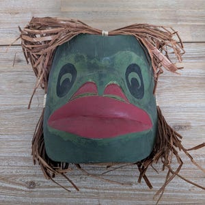 Máscara de rana tallada en cedro de las Primeras Naciones indígenas de la costa oeste, firmada por el artista.
