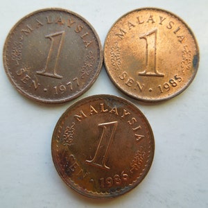 May include: Three bronze Malaysian 1 sen coins. Each coin features the word "MALAYSIA" at the top, the number "1" in the center, and "SEN" and the year at the bottom. The years visible are 1977 and 1985.