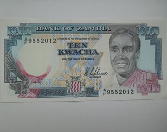 Könnte beinhalten: Ein K10-Banknote der Bank von Sambia mit einem Porträt eines Mannes, einem Adler und dem Text "TEN KWACHA". Die Banknote hat einen hellblauen und weißen Hintergrund mit dem Text "PROMISE TO PAY THE BEARER ON DEMAND."