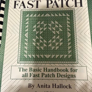 May include: A spiral-bound instructional book titled The Magic of Fast Patch, The Basic Handbook for all Fast Patch Designs by Anita Hallock, Second Edition. The cover features a green and white geometric quilt pattern with a central square.