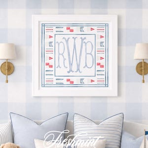 Könnte beinhalten: Ein quadratisches Wandbild in einem weißen Rahmen mit einem zentralen blauen Monogramm der Buchstaben RWB, umgeben von einer Bordüre aus roten und blauen nautischen Signalflaggen, präsentiert auf einer blau-weiß karierten Wand.