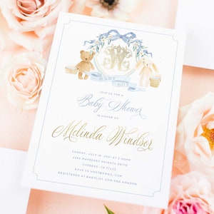 Op de afbeelding: Een witte babyborrel uitnodiging met blauwe en gouden accenten. De uitnodiging heeft een aquarel illustratie van een teddybeer en een konijn die manden vasthouden. De tekst luidt "Baby Boy" en "Doe mee met ons voor een babyborrel ter ere van Melinda Windsor".