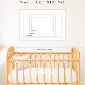 Peut inclure: Un lit b&eacute;b&eacute; en rotin clair avec un matelas et un oreiller blancs. Au-dessus du lit, un sch&eacute;ma affiche les options de dimensionnement des &oelig;uvres d'art murales, notamment 28x43cm, 41x51cm, 46x61cm, 51x76cm et 61x91cm. Le texte "WALL ART SIZING" est en haut.