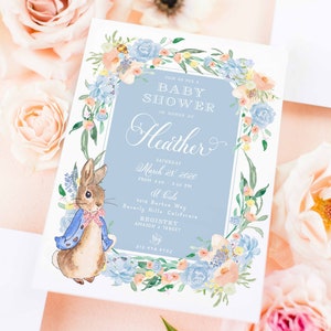 May include: A baby shower invitation with a blue and white floral border. The invitation features a watercolour illustration of Peter Rabbit and the text "Join us for a Baby Shower in honour of Heather, Saturday March 28, 2020 from 2:00 - 5:00 PM at La La, 9018 Burton Way Beverly Hills, California, Registry Amazon & Target, 310 478 1732, freshmint paperie".