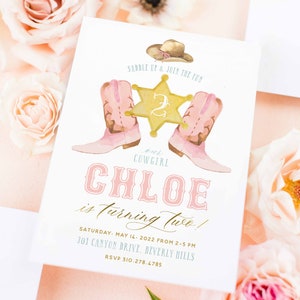 May include: A pink and white invitation with a watercolor illustration of a cowboy hat, two pink boots, and a gold sheriff's star with the number 2 on it. The text reads "Saddle Up & Join the Fun, our Cowgirl Chloe is turning two! Saturday, May 14, 2022 from 2-5 PM, 301 Canyon Drive, Beverly Hills, RSVP 310-278.4785, Freshmint Paperie".