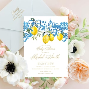 May include: A baby shower invitation with a blue and yellow lemon theme. The invitation features a watercolor illustration of lemons, blue ribbons, and floral details. The text on the invitation reads "Join us for a Baby Shower in honor of Rachel Smith Awaiting the arrival of a Baby Boy Saturday, July 8th, 2:00 PM 301 Canyon Drive, Beverly Hills, CA 90210 RSVP: 310-278-4799 Registry: Babylist.com Freshmint Paperie"