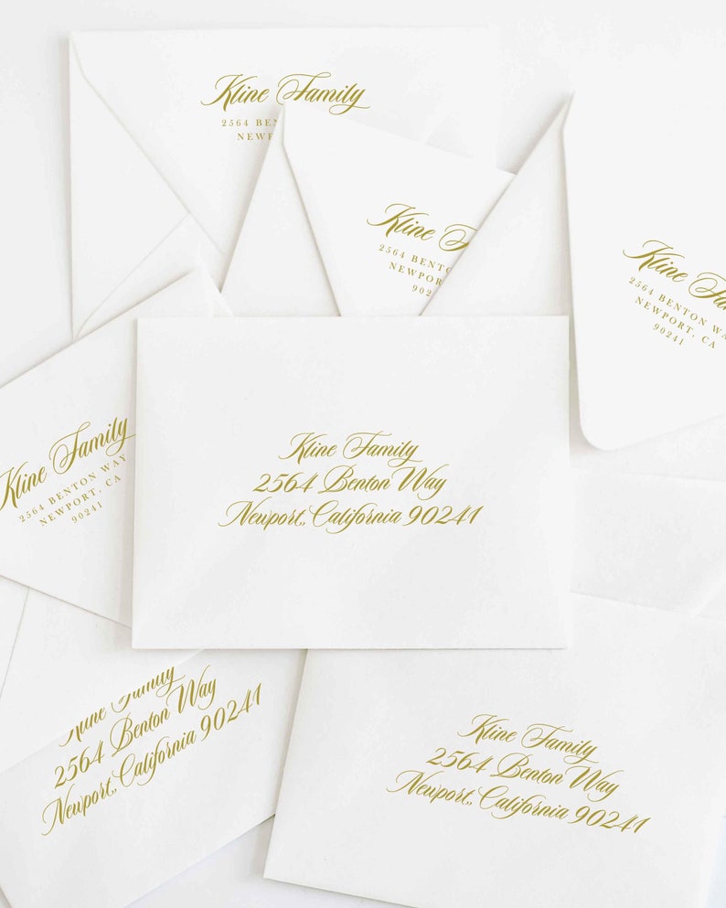 May include: A collection of white envelopes with gold-colored text. The text includes the name "Kline Family" and an address: 2564 Benton Way, Newport, California 90241. The envelopes are arranged in a slightly overlapping pattern.
