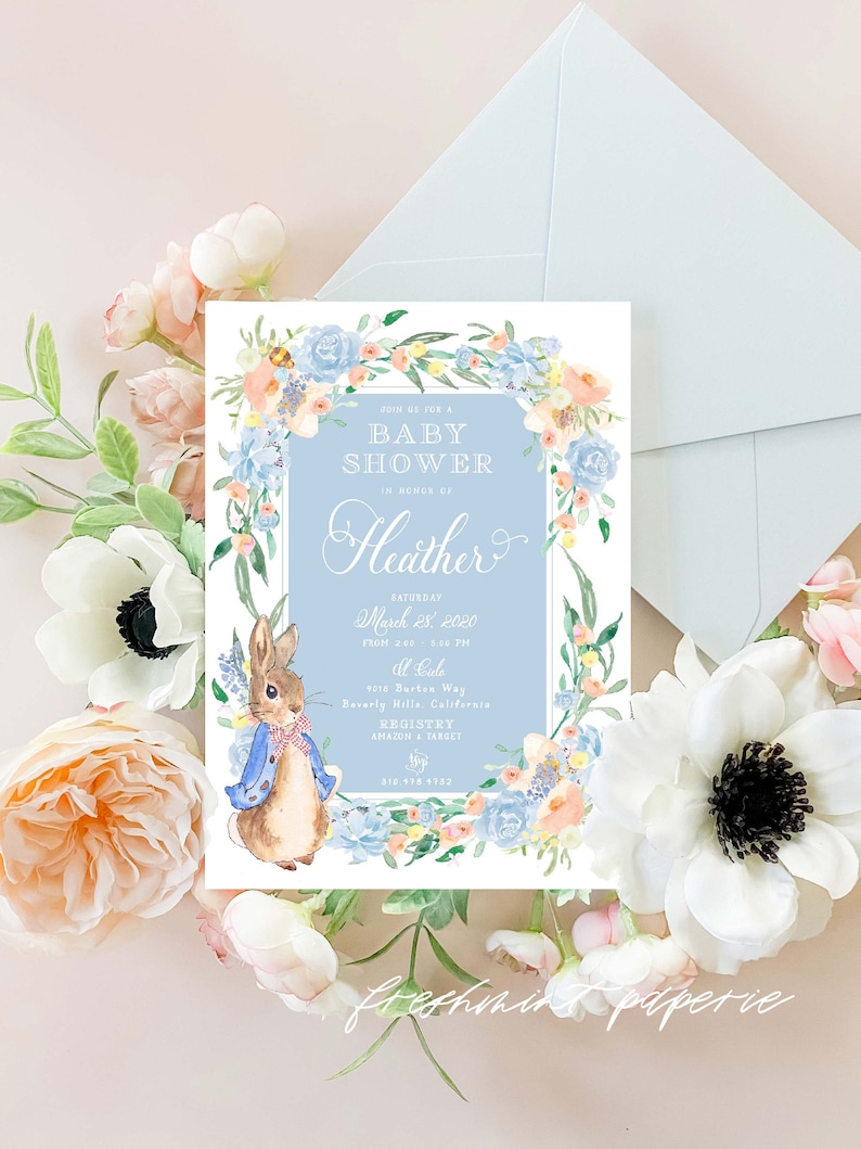 May include: A baby shower invitation with a blue and white floral border. The invitation features a watercolour illustration of a rabbit wearing a blue jacket and a bow tie. The text on the invitation reads "Join us for a Baby Shower in honour of Heather, Saturday, March 28, 2020 from 2:00 - 4:00 PM, at Cade, 4018 Durten Way, Beverly Hills, California. Registry: Amazon & Target, 210.470.4732."