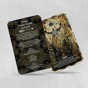 May include: Two cards with a gold and black design. The card on the left has instructions for a three rune layout. The card on the right has a rune symbol and the word "Gebo".