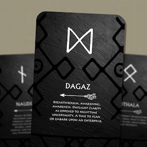 以下が含まれることがあります： 黒と白のルーンカード。Dagazのシンボルと「BREAKTHROUGH, AWAKENING, AWARENESS. DAYLIGHT CLARITY AS OPPOSED TO NIGHTTIME UNCERTAINTY. A TIME TO PLAN OR EMBARK UPON AN ENTERPRISE.」というテキストが書かれている。