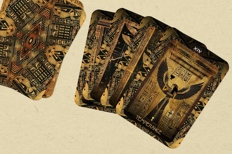 May include: A set of four tarot cards with an Egyptian theme. The cards are decorated with gold and black hieroglyphics and feature a winged goddess figure. The card on top reads "XIV TEMPERANCE".