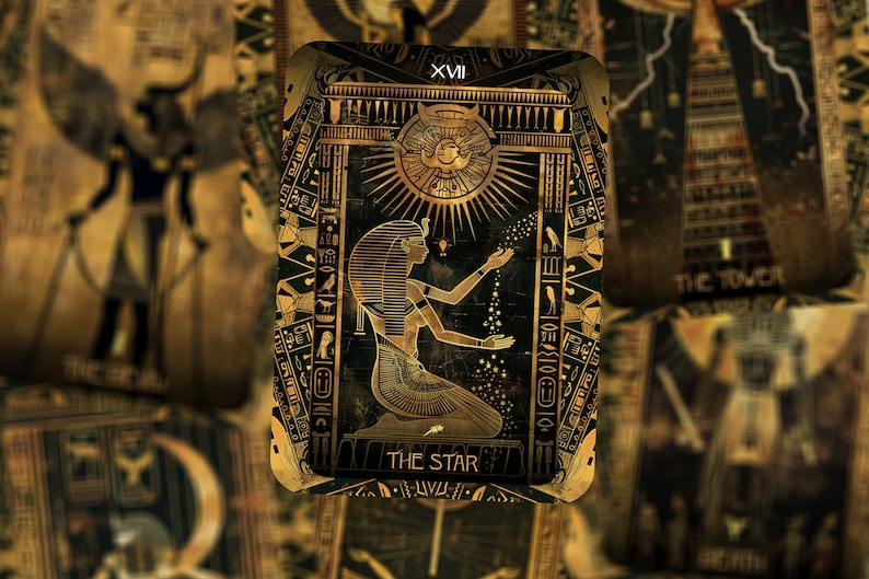 May include: The Star tarot card features a gold and black design with an Egyptian goddess pouring water from a pitcher. The card number XVI is in the top left corner and the words "The Star" are at the bottom of the card.