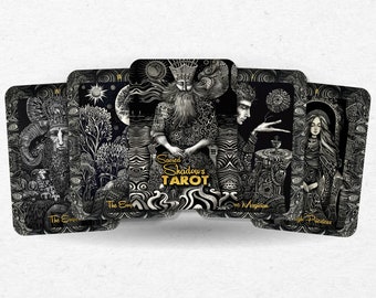 Puede incluir: Un juego de cartas de tarot de la baraja Sacred Shadows Tarot. Las cartas presentan ilustraciones en blanco y negro con detalles dorados. Las cartas están dispuestas en forma de abanico, con la carta titulada "El Emperador" a la izquierda y la carta titulada "La Sacerdotisa" a la derecha. La carta del centro está titulada "El Mago" y presenta el texto "Sacred Shadows Tarot".