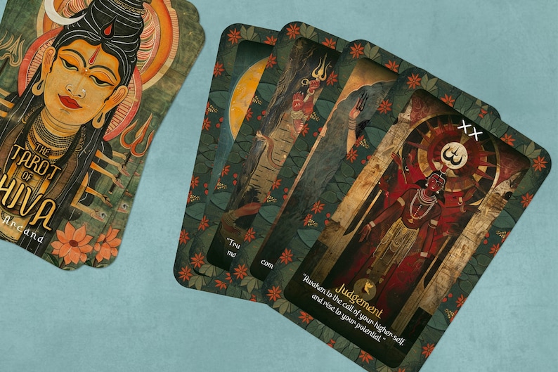 May include: A tarot deck with a green and gold background featuring a colorful illustration of a deity with multiple arms. The card is labeled "Judgement" and has the number "XX" in the top right corner. The text below the illustration reads "Awaken to the call of your higher self and rise to your potential."