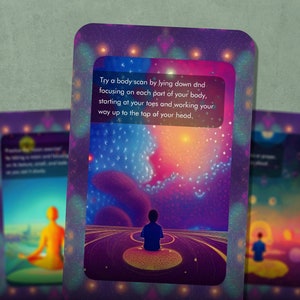 May include: A purple card with a colorful galaxy background and a person sitting in the foreground. The card has text that reads "Try a body scan by lying down and focusing on each part of your body, starting at your toes and working your way up to the top of your head."