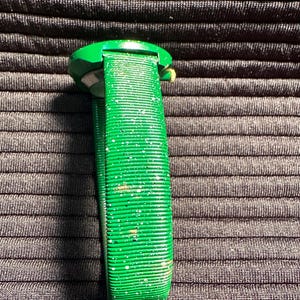 May include: A green watch with a sparkly green band. The watch face is round and has a gold rim.