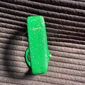 May include: A green wristwatch with a sparkly green band. The watch face is not visible.
