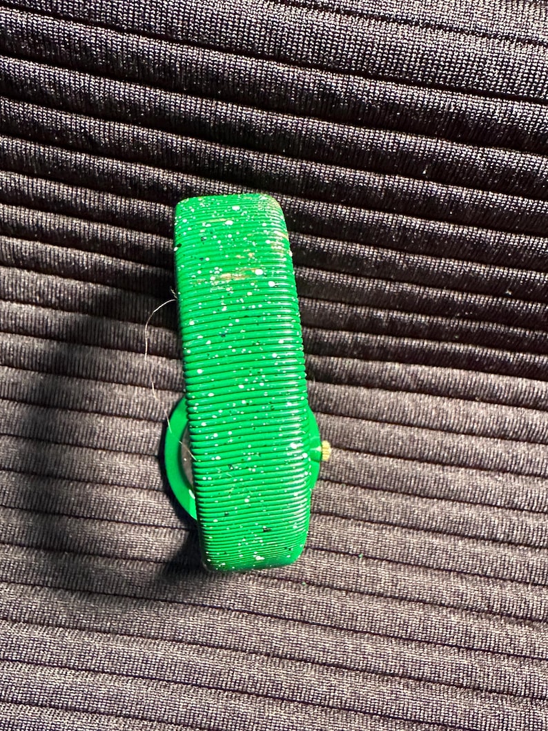 May include: A green wristwatch with a sparkly green band. The watch face is not visible.