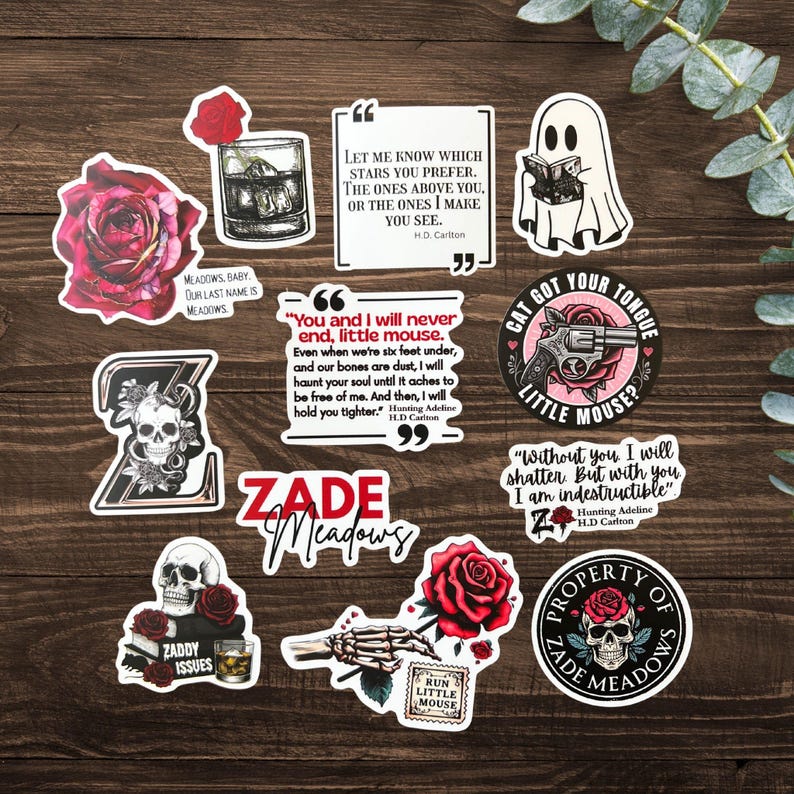 K&ouml;nnte beinhalten: Eine Sammlung von Aufklebern mit gotischen und romantischen Themen. Designs umfassen Rosen, Totenk&ouml;pfe, Zitate und einen Geist, der ein Buch liest. Die Aufkleber enthalten Texte wie "Zade Meadows", "Run Little Mouse" und "Cat Got Your Tongue."