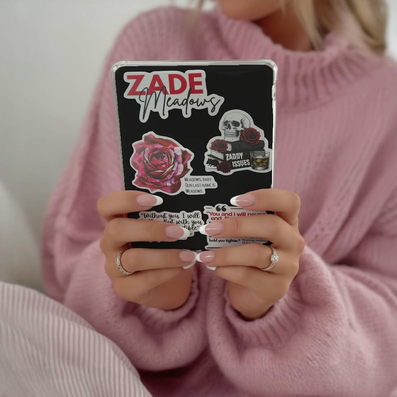 K&ouml;nnte beinhalten: Schwarze Handyh&uuml;lle mit Aufklebern. Die Aufkleber enthalten den Text "ZADE Meadows", eine Rose, einen Totenkopf und den Text "ZADDY ISSUES". Zus&auml;tzlicher Text lautet "Without you I will" und "You and I will".