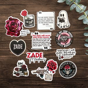 Könnte beinhalten: Eine Sammlung von Vinyl-Aufklebern mit düsteren romantischen Motiven, darunter rote Rosen, Totenköpfe, ein lesendes Gespenst, ein Revolver und Zitate von H.D. Carlton. Der Text umfasst ZADE, ZADE MEADOWS und verschiedene literarische Auszüge.