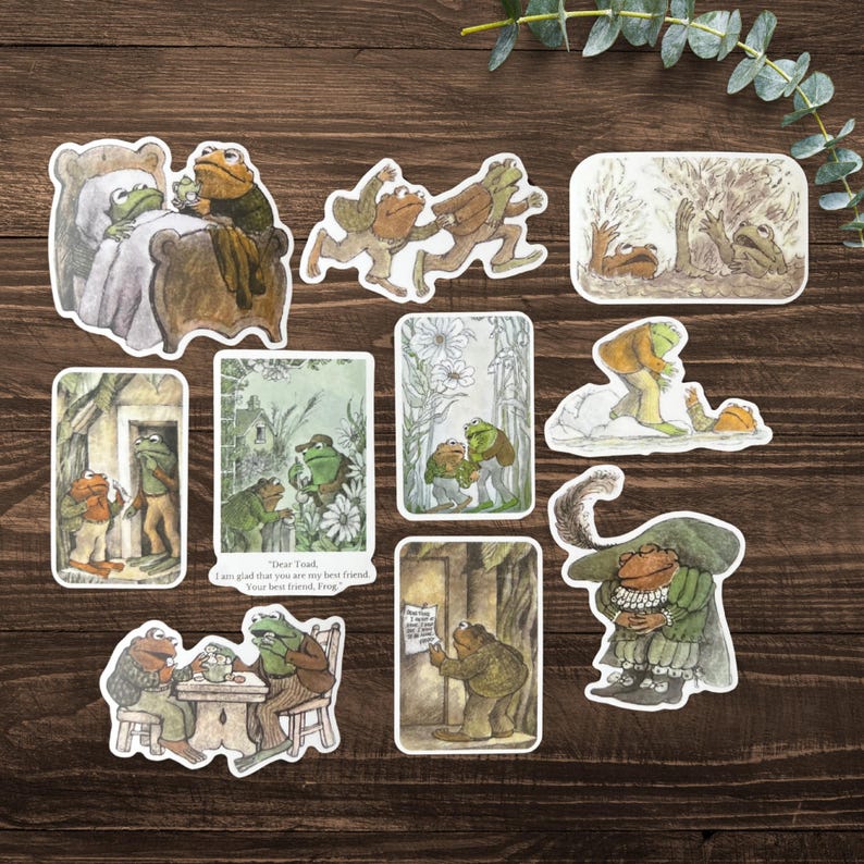 Puede incluir: Una colecci&oacute;n de pegatinas ilustradas con ranas antropom&oacute;rficas en varias escenas. Las pegatinas representan ranas en diferentes entornos, incluyendo una cama, una fiesta de t&eacute; e interactuando entre s&iacute;. La paleta de colores incluye verdes, marrones y cremas.
