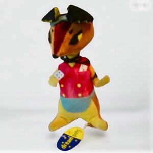 Pu&ograve; includere: Un peluche a forma di animale con un gilet rosso, pantaloncini blu e un cappello nero. Il giocattolo ha un'etichetta gialla con la scritta "dream pets". L'animale ha una faccia da volpe con occhi neri e naso rosso.