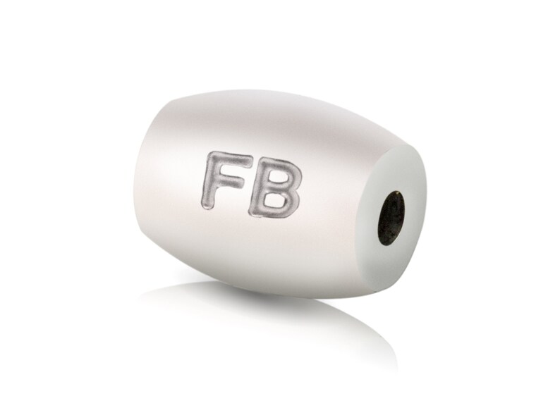 May include: White oval bead with the letters "FB" engraved on the side.