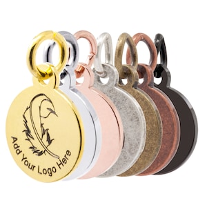May include: A set of seven round metal charms with a loop at the top. The charms are in different finishes: gold, silver, rose gold, antique silver, antique brass, copper, and black. The gold charm has a feather design and the text "Add Your Logo Here".